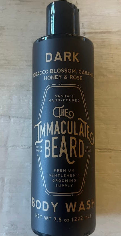 Body wash bottle for men labeled DARK with notes of tobacco, honey, caramel and rose.